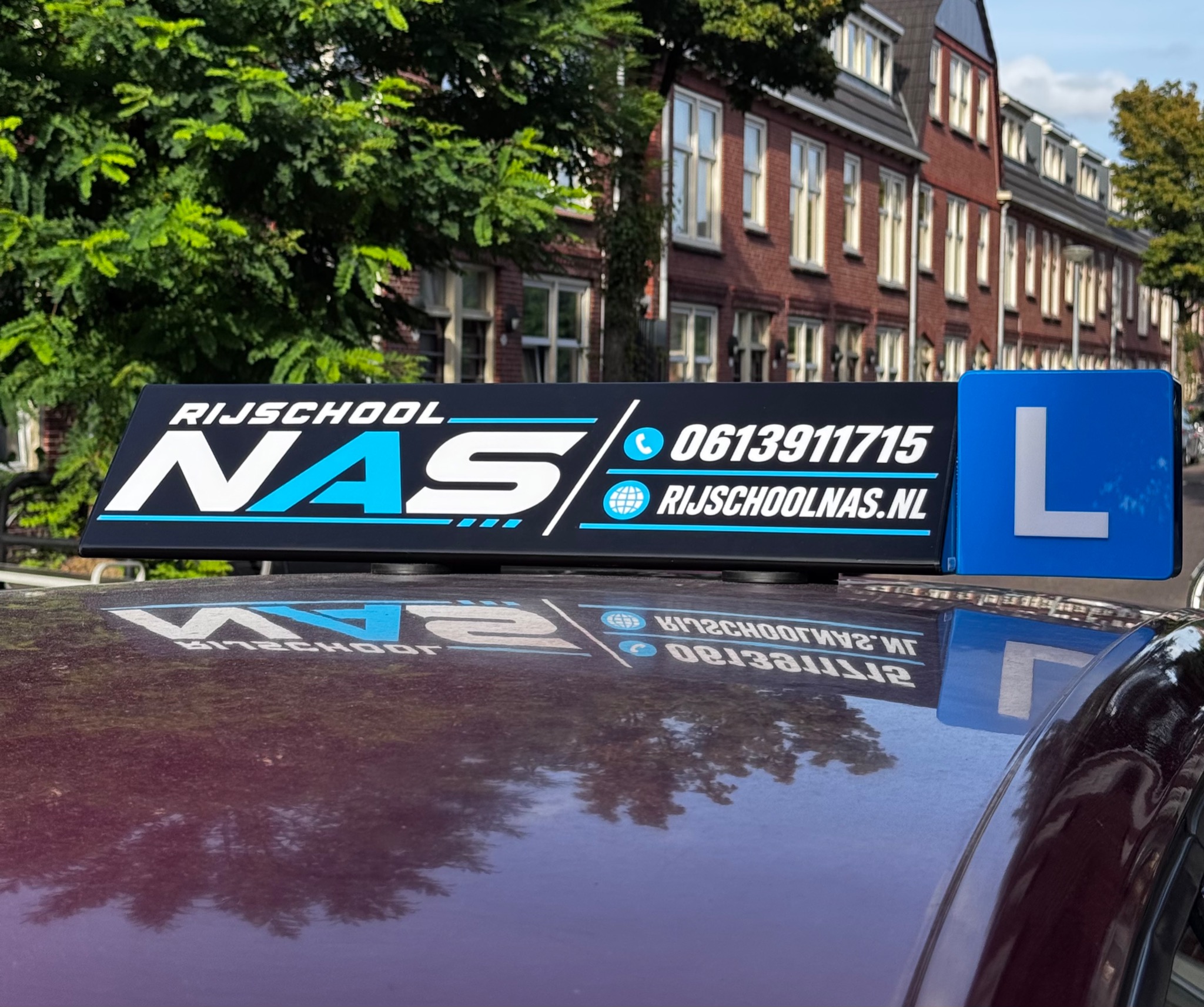 Rijschool NAS dakbord op een lesauto